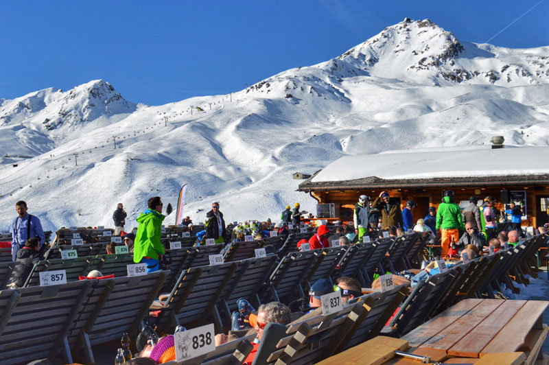 Skiers enjoying the sunny terrace at Arosa ski resort in Switzerland