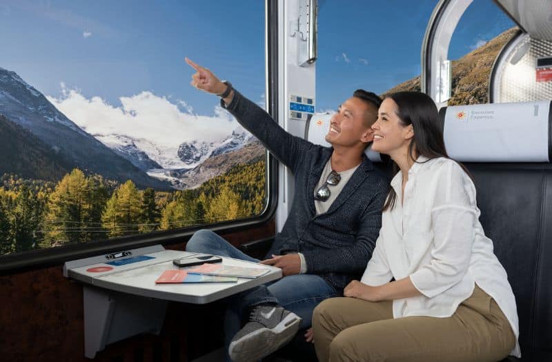 Couple admiring the scenery from the Bernina Express train in Switzerland