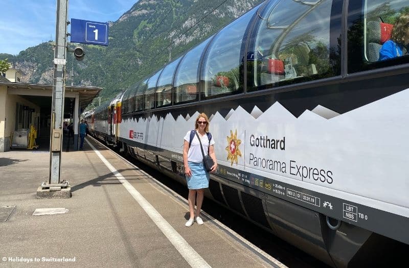 Women standing beside Gotthard Panorama Express train in Fluelen, Switzerland