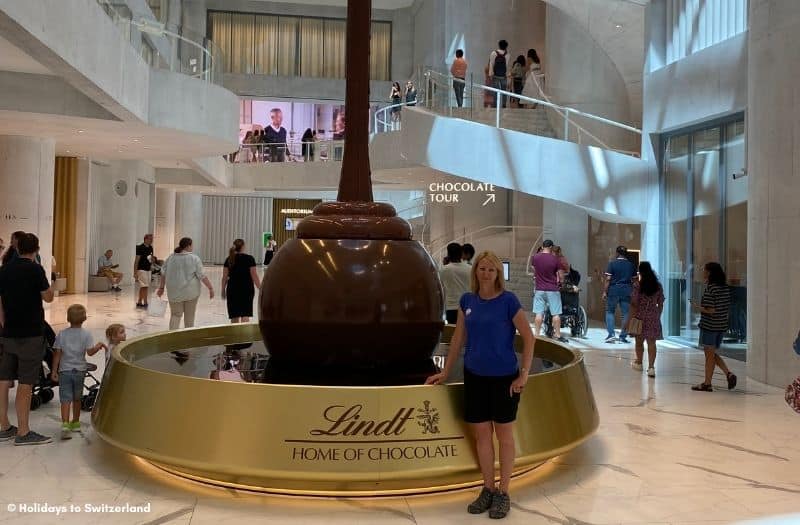 Woman stands beside the chocolate fountain at Lindt Home of Chocolate near Zurich, Switzerland