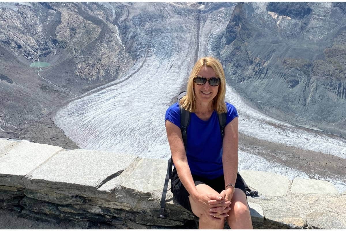 Woman sitting in front of a glacier in Switzerland