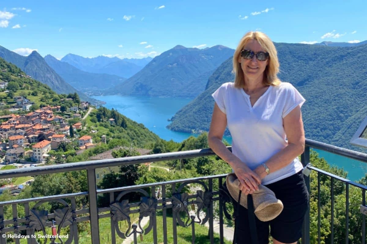 Women standing on viewing platform with the village of Bre and Lake Maggiore in the background