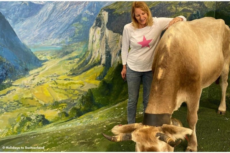 Woman standing beside a cow at a Selfie Museum in Switzerland