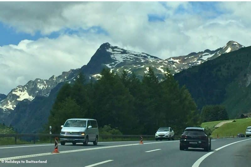 Cars drive on a mountain road