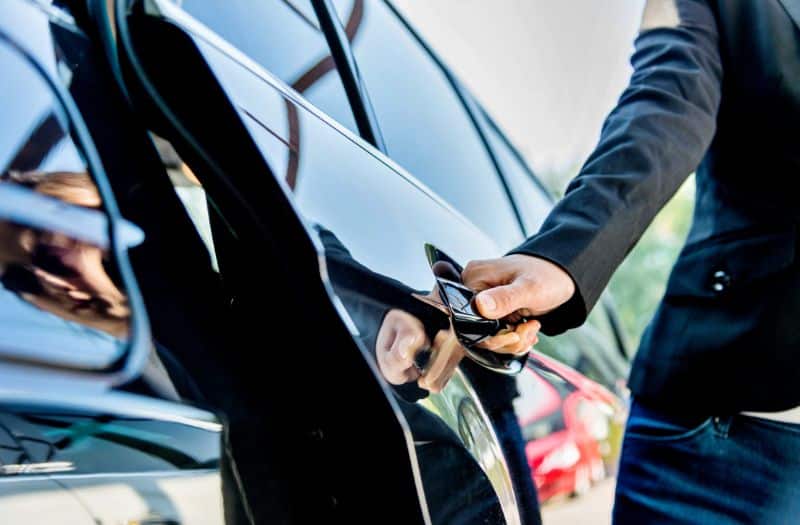 Man opening rear door of a car