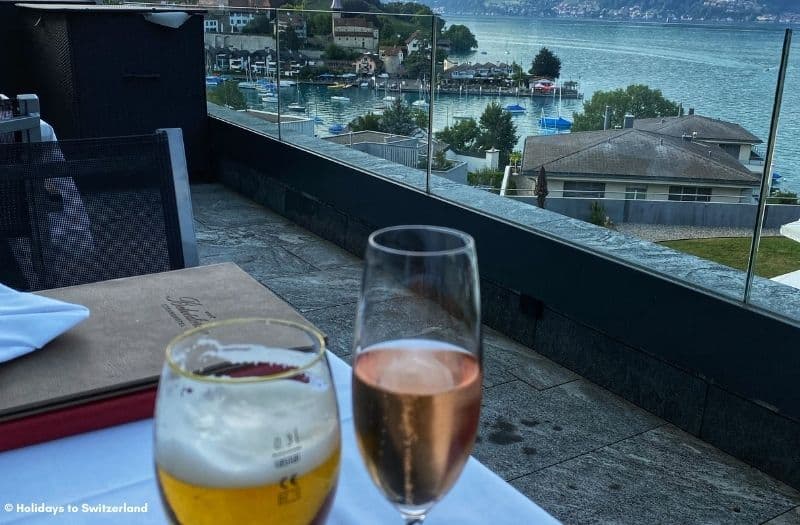 Two alcoholic drinks on a table overlooking the Lake Thun at Spiez in Switzerland