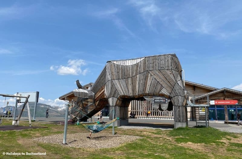 Children's playground with giant wooden cow at Mannlichen in Switzerland