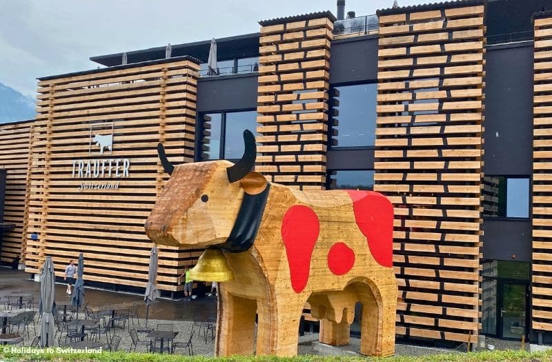 A large wooden cow by the entrance to Trauffer Switzerland.