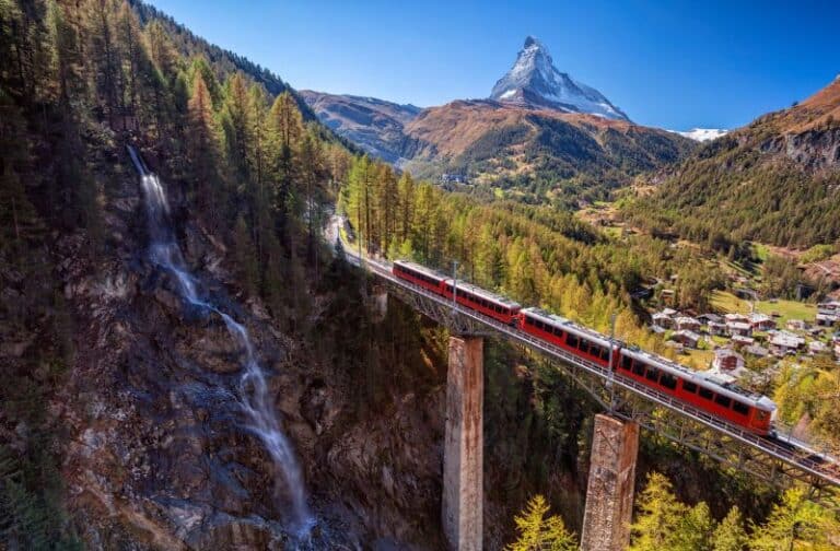 Switzerland's Glacier Express train crosses a bridge with the Matterhorn in the background