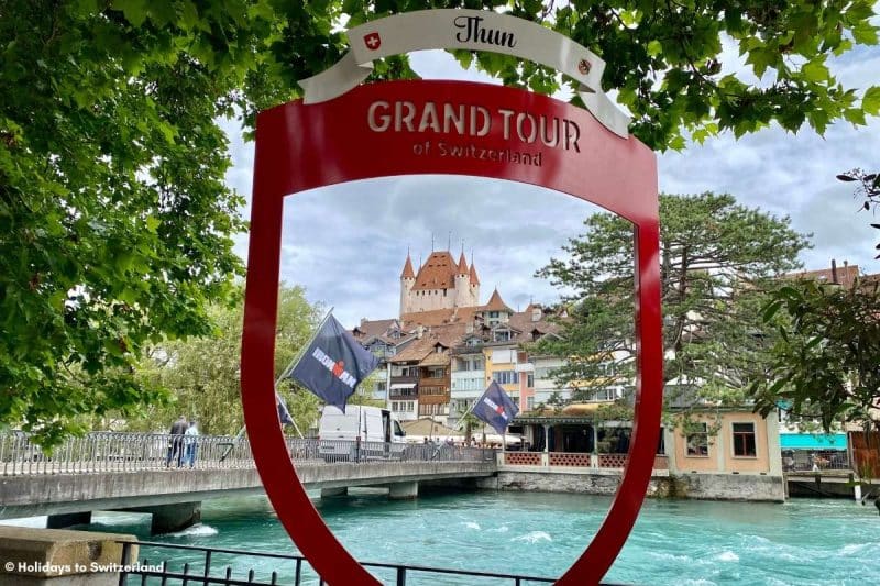 Thun Castle seen through a Grand Tour of Switzerland sign