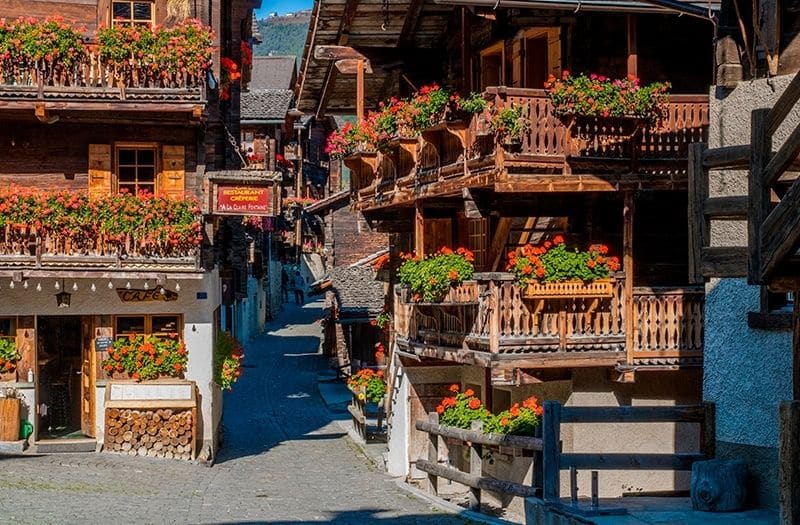 Wooden chalets line a street in Grimentz, one of the most beautiful villages in Switzerland