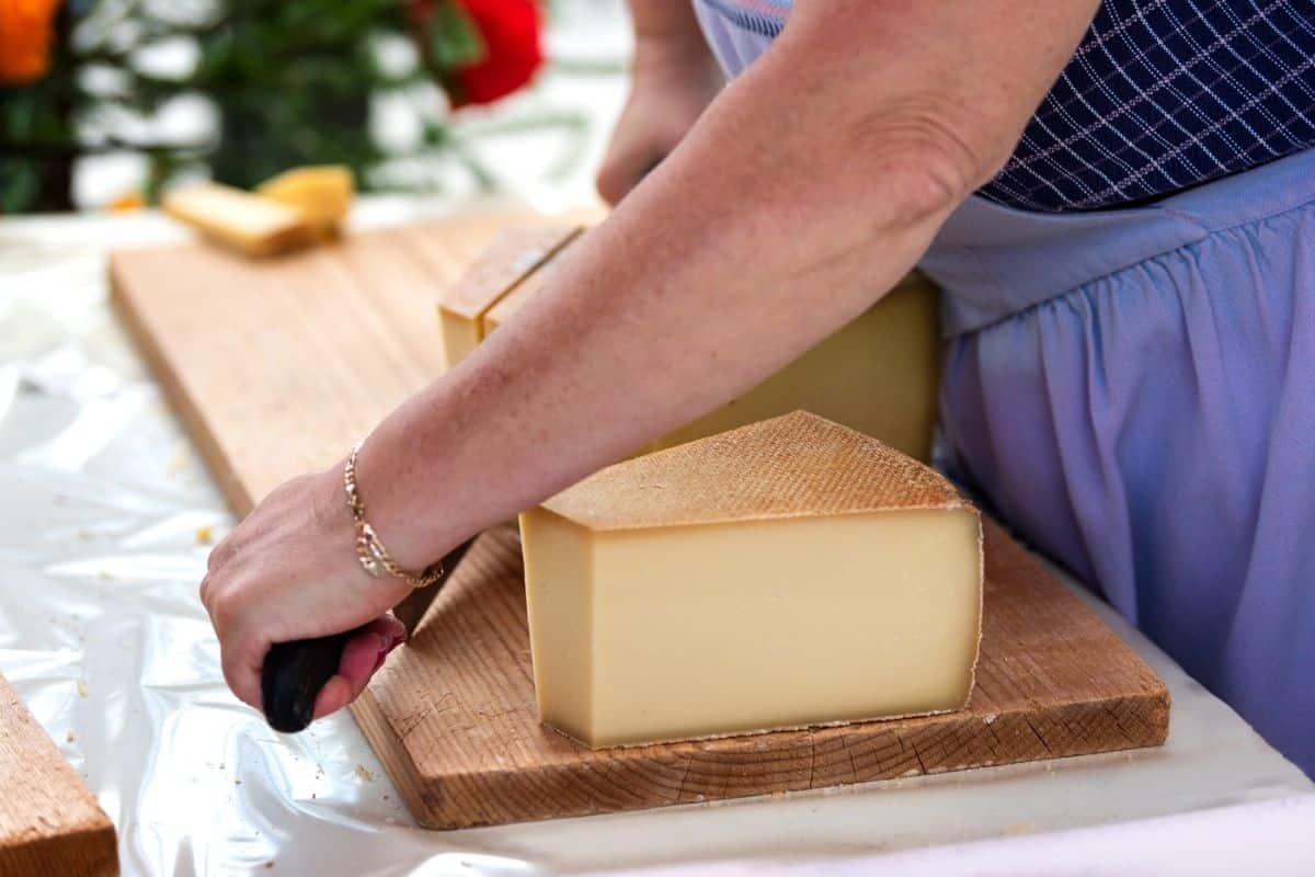 Woman cutting cheese on a board