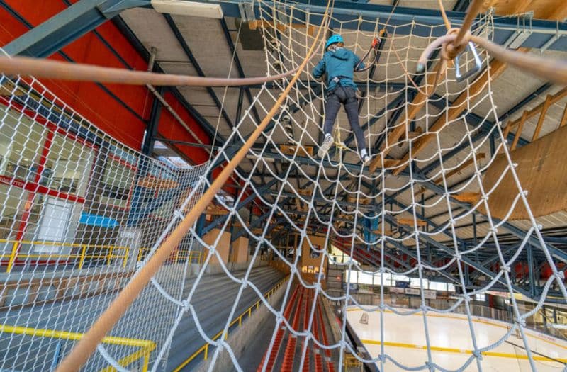 Boy climbing on rope course at the indoor rope park in Grindelwald, Switzerland