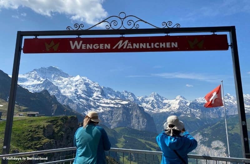 Two women taking photos of the Swiss Alps from the Mannlichen viewpoint