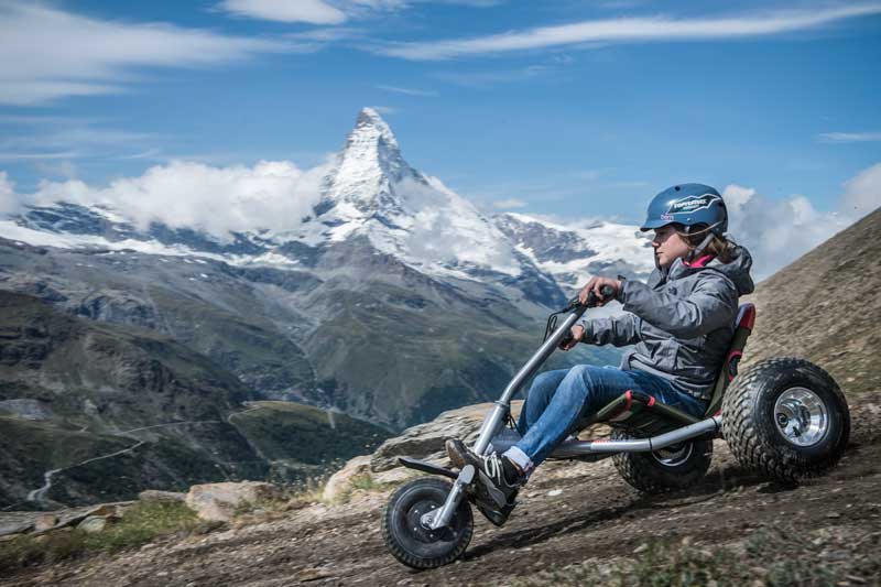 Girl riding a mountain cart with the Matterhorn in the background