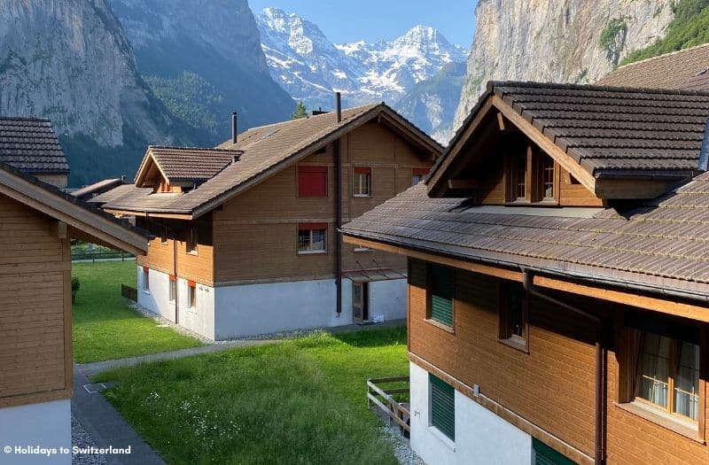 Chalet-style buildings in front of the Bernese Alps