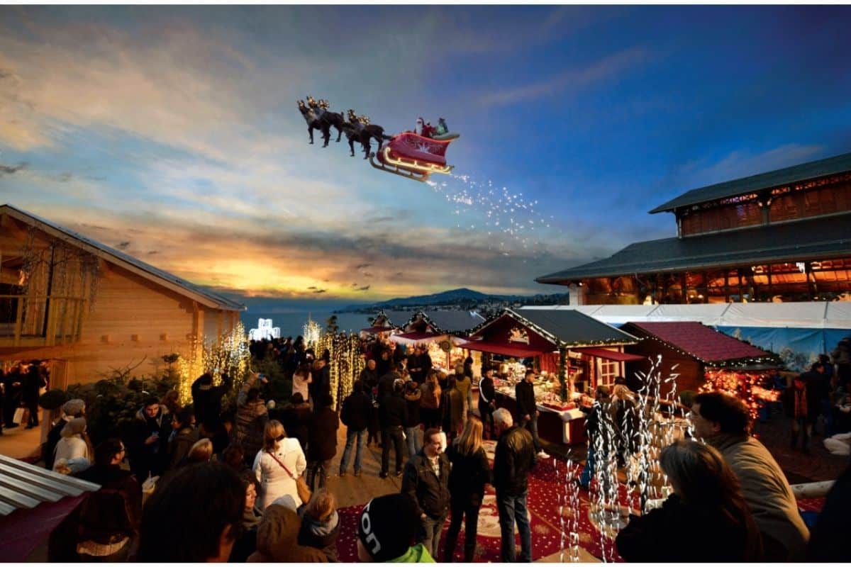 Santa in his sleigh pulled by reindeer in the sky above Montreux Christmas market