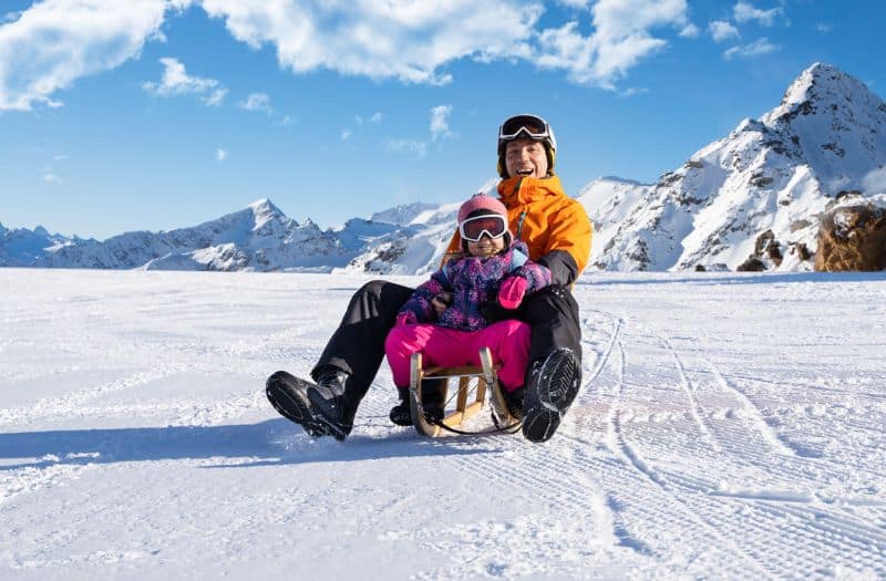 Man and child sledding in Switzerland