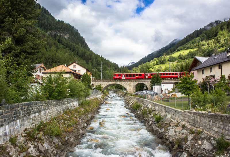 Red train crossing a bridge in Switzerland