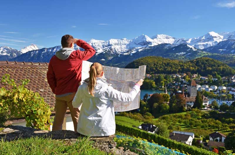 Couple looking at a map and views of the Swiss Alps.