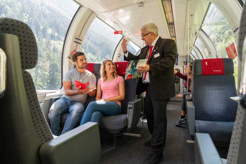 Train conductor chatting to passengers onboard the Gotthard Panorama Express