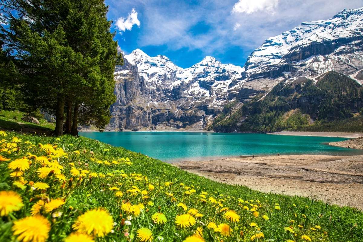 Lake Oeschinen in front of snow capped mountains