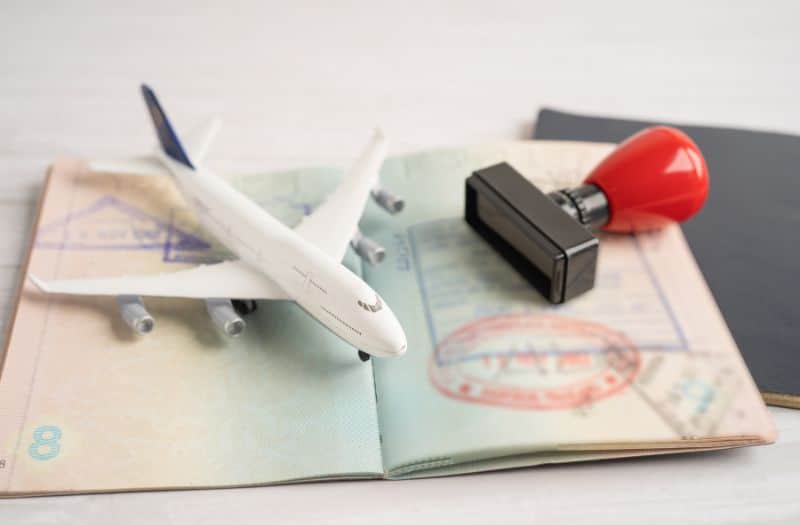 Toy aeroplane on open passport with visa stamp