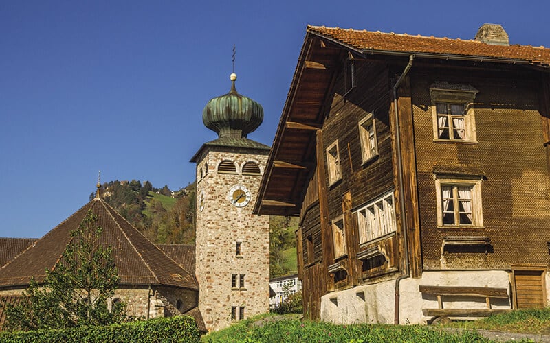 Wooden chalet and church tower in Triesenberg, Principality of Liechtenstein