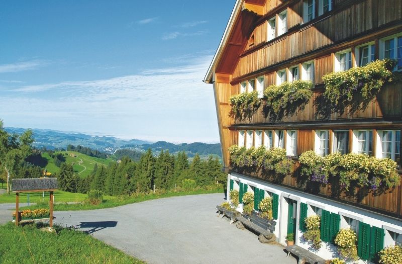 A wooden chalet at Trogen, Switzerland with views over the rolling hills.