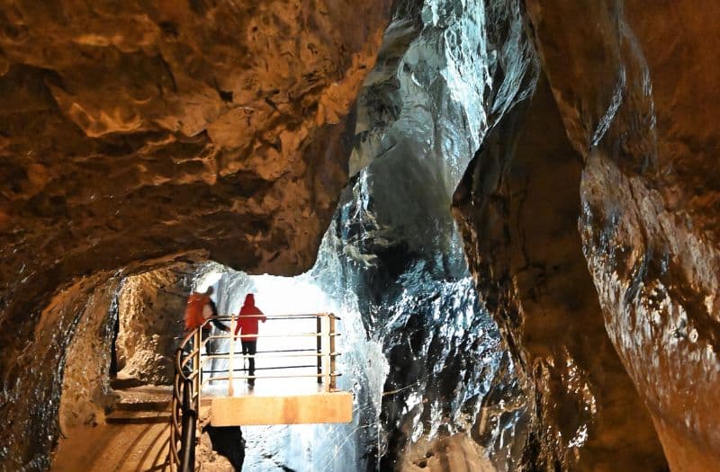 People standing on a viewing platform inside a glacier cave to see the Trümmelbach Falls near Lauterbrunnen in Switzerland