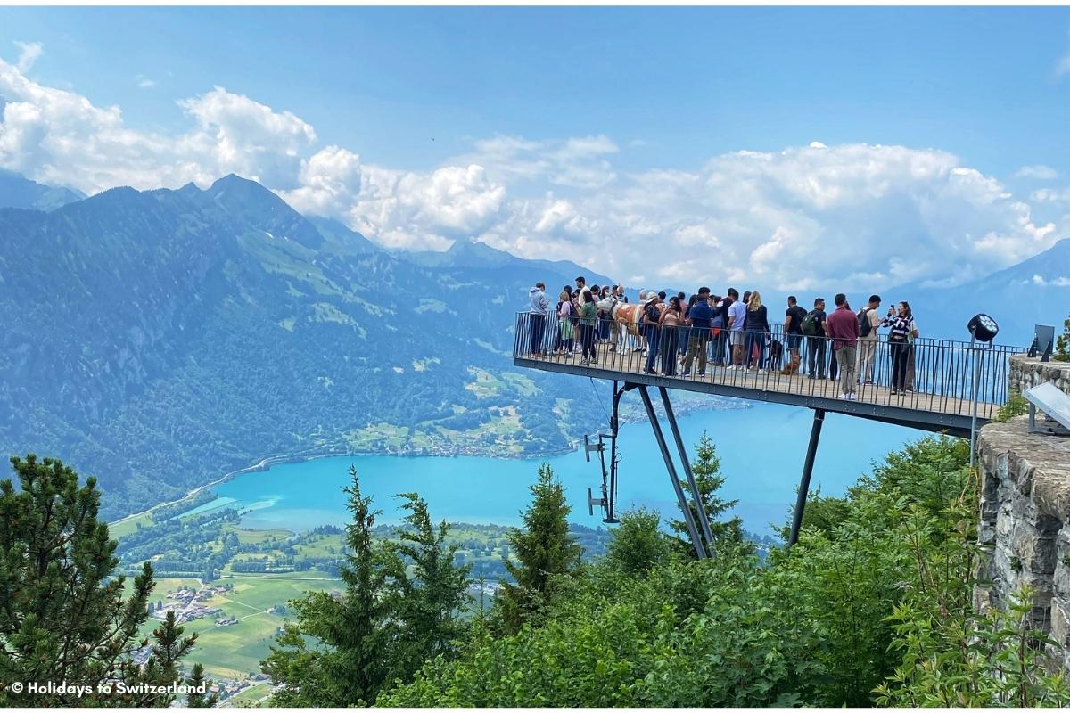 People standing on Two Lakes Bridge at Harder Kulm and looking over Lake Thun