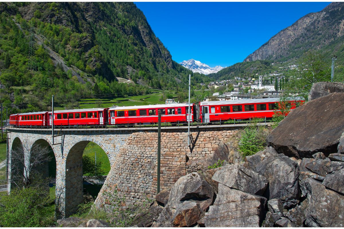 Red train crossing a viaduct in Switzerland