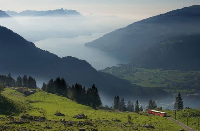 View of Schynige Platte cogwheel train with Lake Thun in the distance