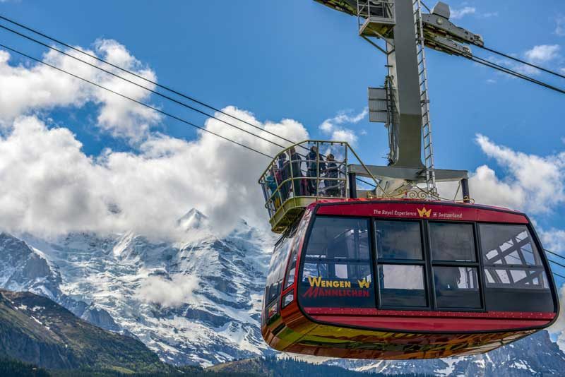 Passengers stand on the rooftop balcony of the Wengen - Mannlichen cable car