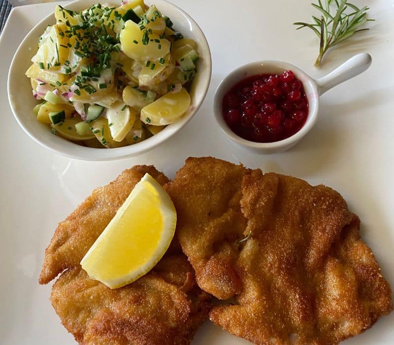 Wiener Schnitzel with potato salad and cranberry sauce at Hotel Restaurant Gloria Beatenberg