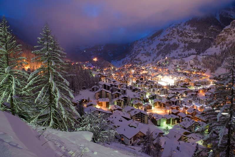 View overlooking snowy Zermatt at night during winter.