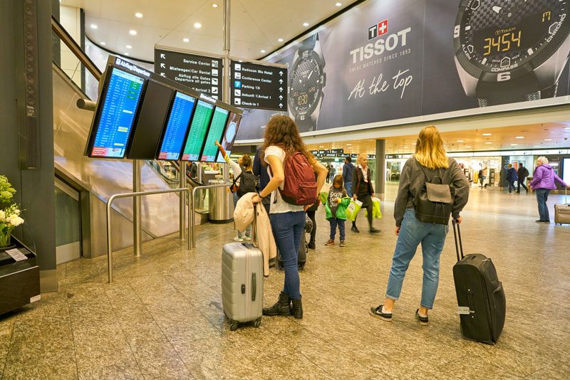 Two women looking at departure boards at Zurich airport