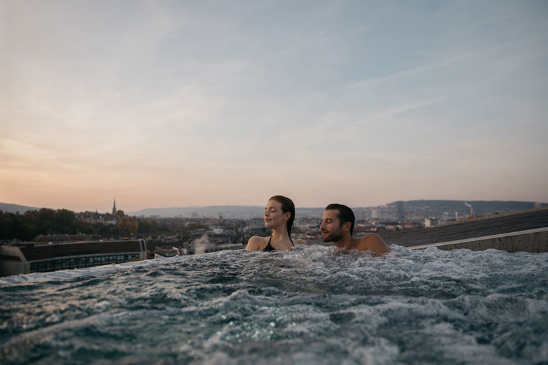 Couple enjoying the rooftop spa at Hurlimannbad and Spa in Zurich.