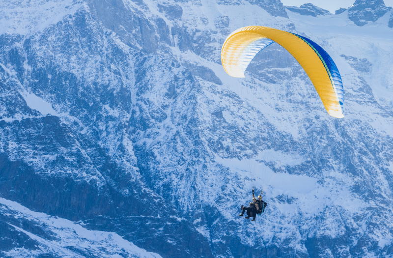 Two people paragliding above the Swiss Alps near Lauterbrunnen.